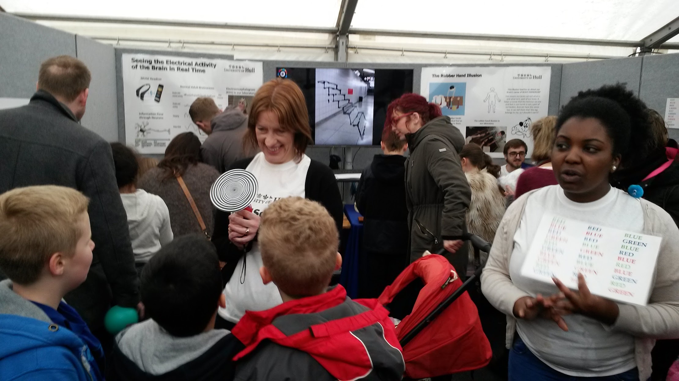Children and visitors trying activities at a psychology stall.